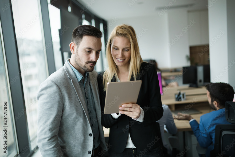 Businesspeople discussing while using digital tablet in office Businesspeople discussing while using digital tablet in office