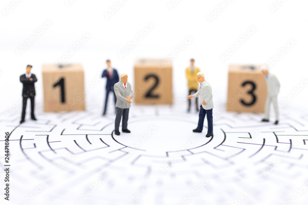 Miniature people : Businessman standing on wooden blocks with sequential numbers. Image use for business concept. Miniature people : Businessman standing on wooden blocks with sequential numbers. Image use for business concept.