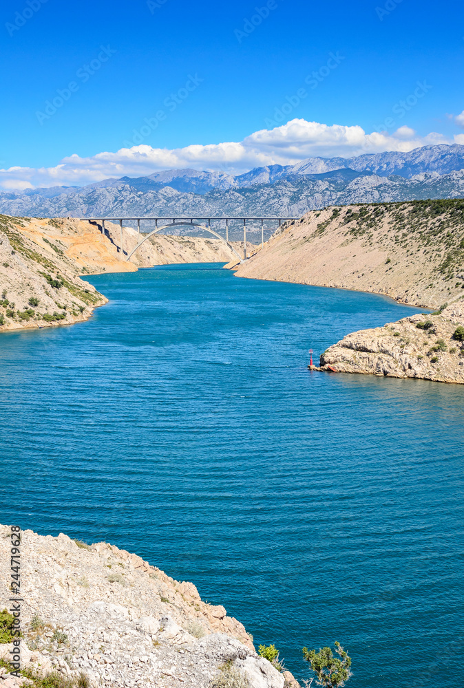Fototapeta premium Mountain landscape with a concrete bridge across the bay.
