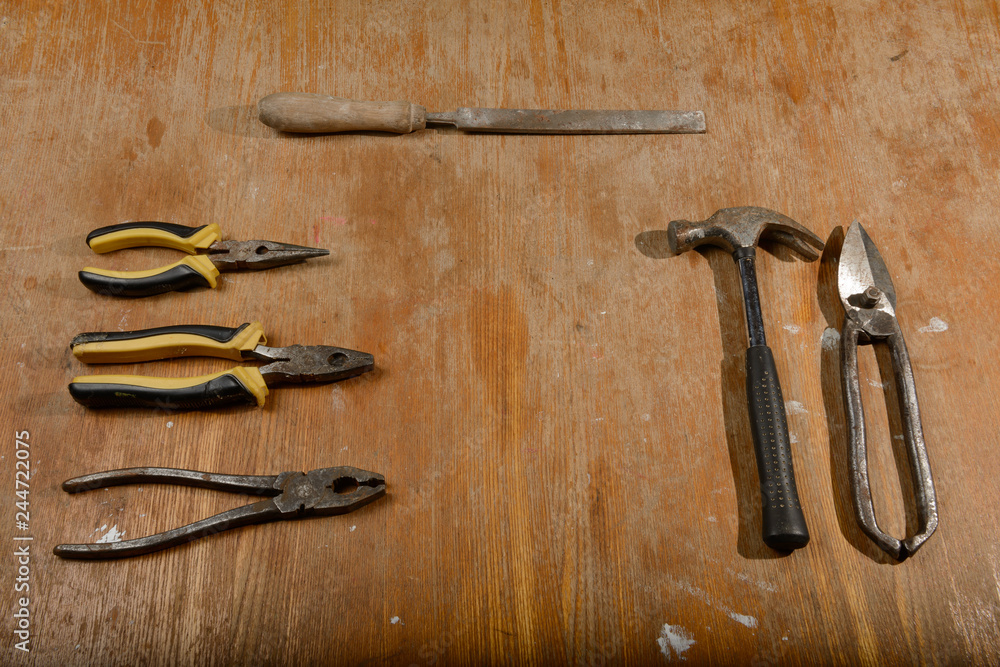 several old tools lie on a dirty wooden table several old tools lie on a dirty wooden table