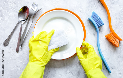 concept of woman washing dishes on gray background top view photo