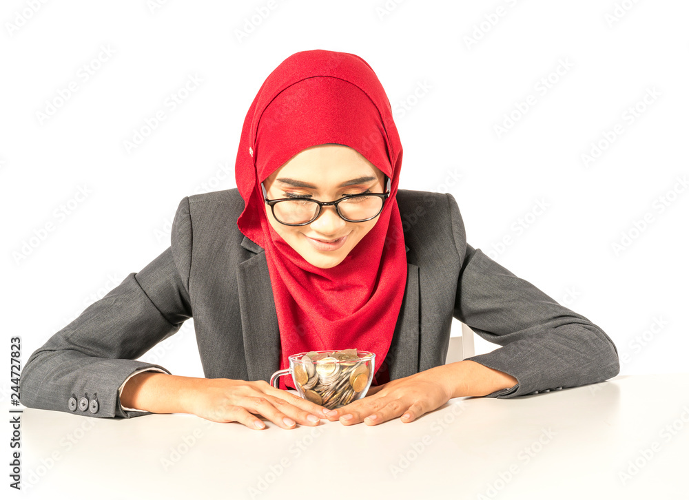 Hijab businesswoman holding cup glass full with coins. Financial concept. Hijab businesswoman holding cup glass full with coins. Financial concept.