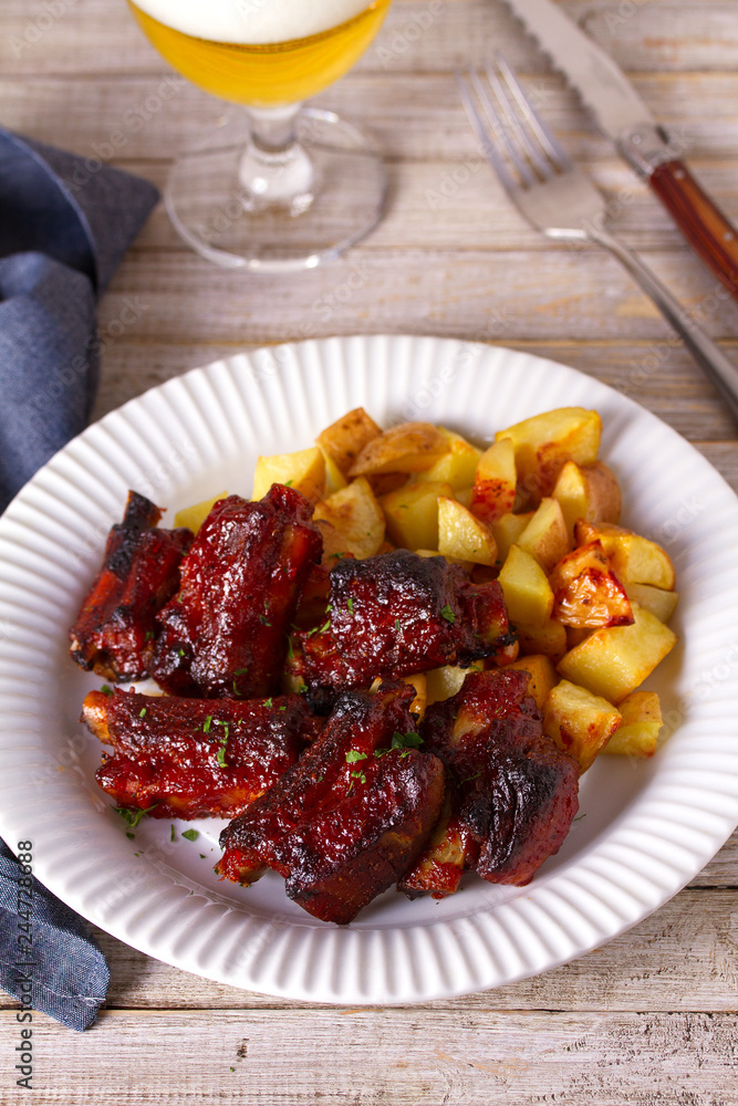 Grilled pork spare ribs with fries. Roasted sliced barbecue ribs Grilled pork spare ribs with fries. Roasted sliced barbecue ribs