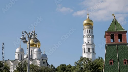 Close up view on Kremlin tower and beautiful white cathedrals with golden domes against blue sky in Moscow, Russia