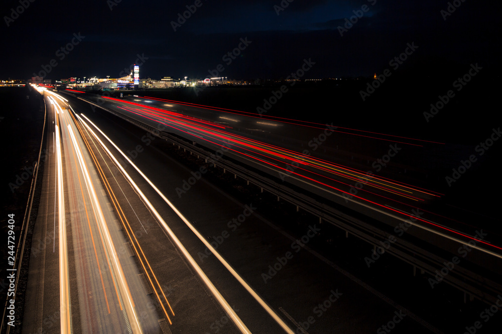 Motion blurred light tracks glowing to the darkness of highway traffic to the city just after sunset. Creative long time exposure photography. Motion blurred light tracks glowing to the darkness of highway traffic to the city just after sunset. Creative long time exposure photography.