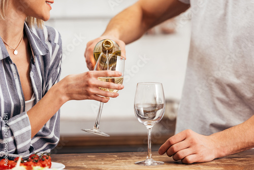 cropped view of boyfriend pouring wine for girlfriend