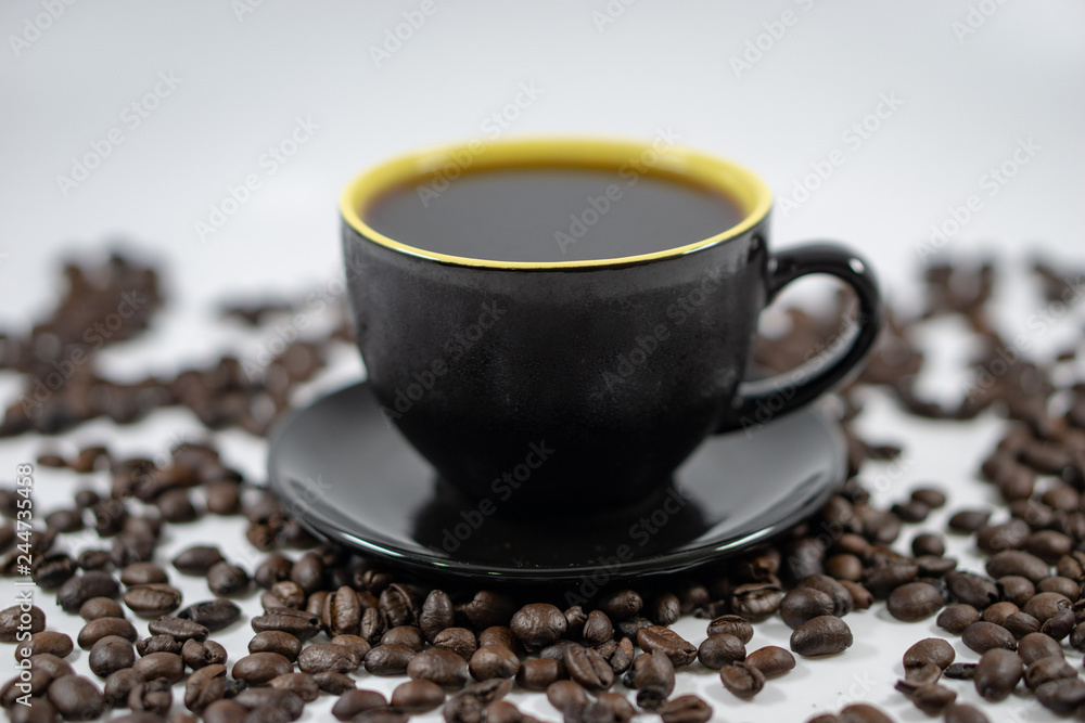 Fototapeta premium A cup of coffee on coffee beans background. Selective focus.