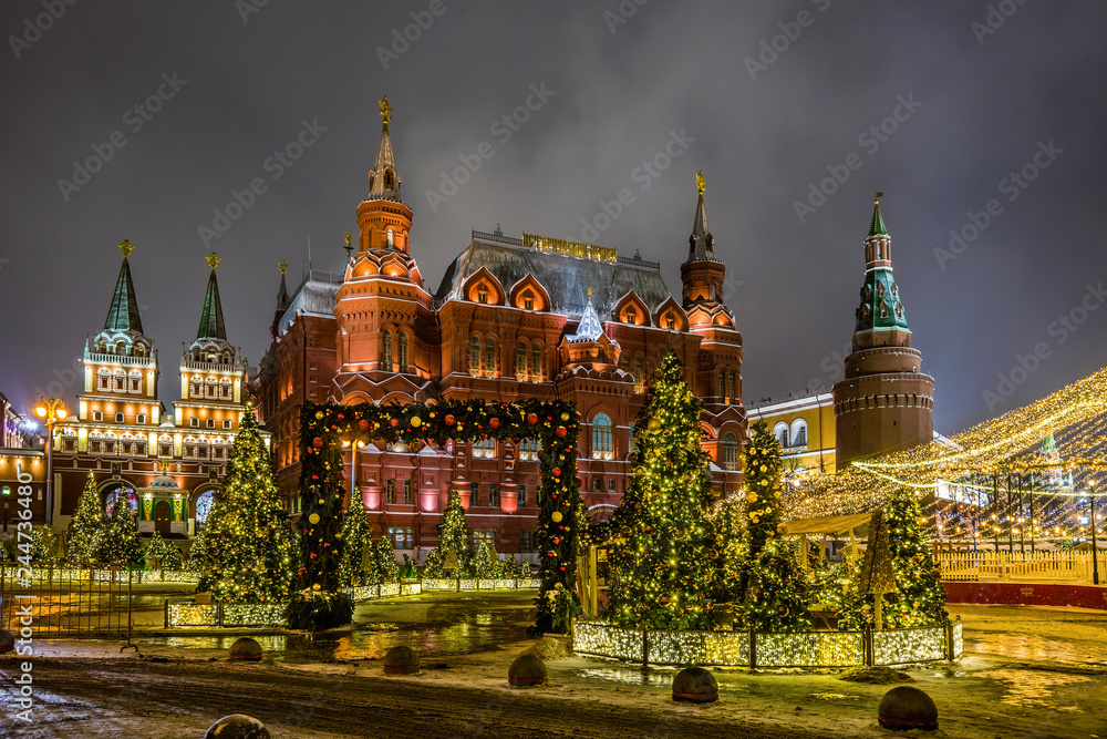 Winter night view of the State historical Museum, Iverskaya chapel and Uglovaya Arsenal'naya tower of Kremlin with the Christmas decoration on the Manezhnaya square in Moscow, Russia.