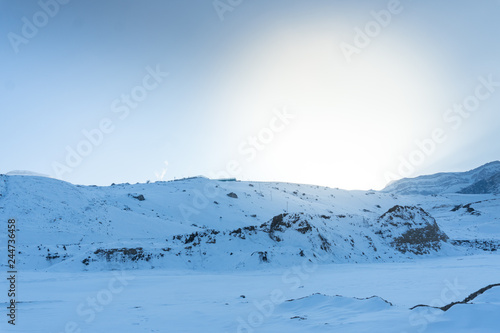 At a snowy mountain peak. Half of Mountain range covered with snow. photo