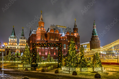Winter night view of the State historical Museum, Iverskaya chapel and Uglovaya Arsenal'naya tower of Kremlin with the Christmas decoration on the Manezhnaya square in Moscow, Russia.