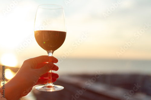A glass of red wine at sunset.