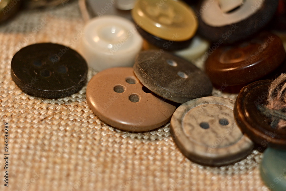 Scattered multicolored buttons on linen fabric Scattered multicolored buttons on linen fabric