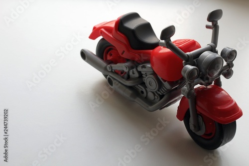 Red plastic motorbike toy isolated on white background.