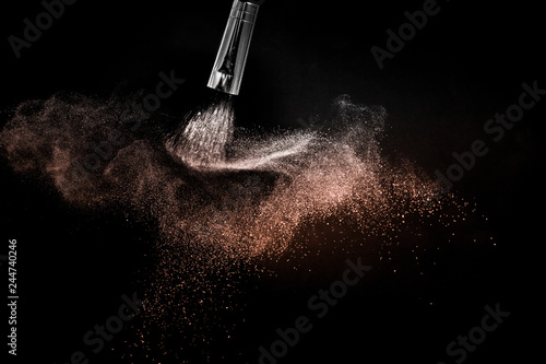 Cosmetic brush with living Coral Color cosmetic powder spreading for makeup artist and graphic design in black background