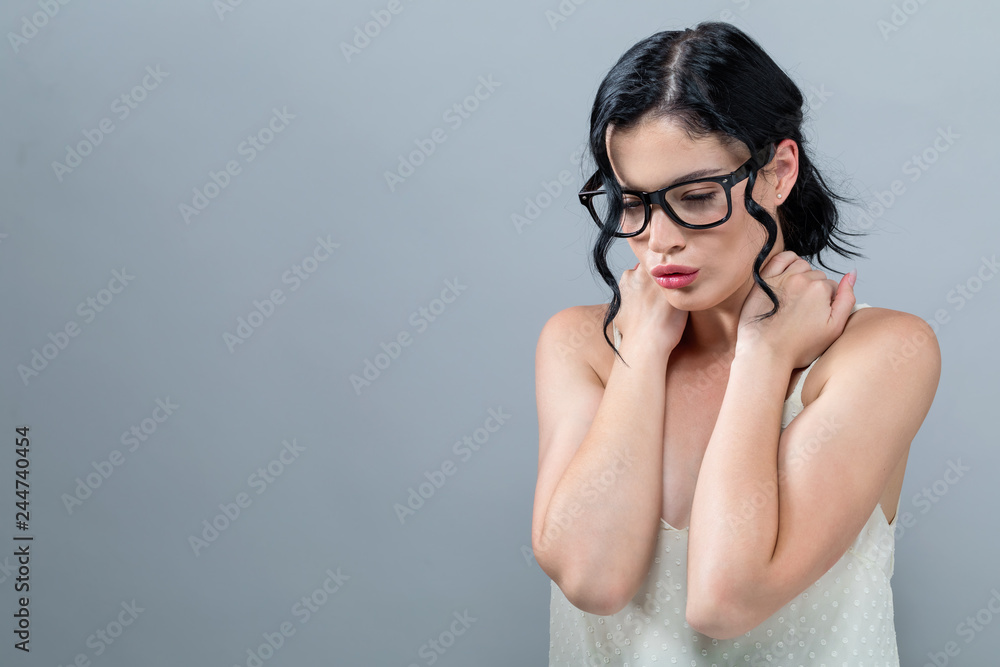 Young woman suffering from neck pain on a solid background Young woman suffering from neck pain on a solid background
