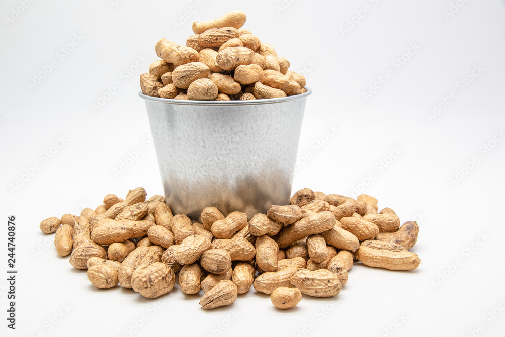 Peanuts in a tin bucket on white background. Peanuts in a tin bucket on white background.