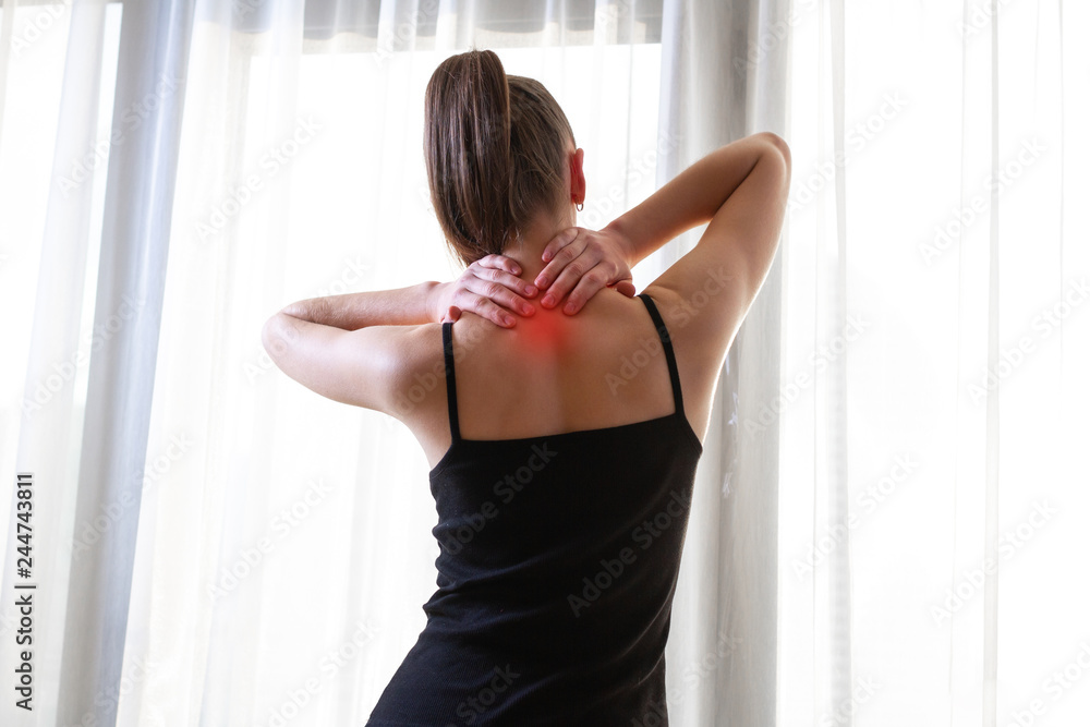 Young woman massaging her neck because of suffering from pain neck, stretching the muscles. Young woman massaging her neck because of suffering from pain neck, stretching the muscles.