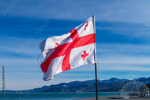 Georgian flag waving in the wind on the background of blue, clear sky