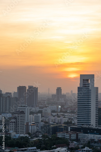 Beautiful sunset over modern office building tower in business district downtown center of Bangkok.Cityscape urban of Bangkok city at night in warm light colour tone. Construction business concept.