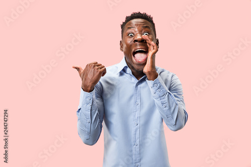 Secret, gossip concept. Young afro man whispering a secret behind his hand. Businessman isolated on trendy pink studio background. Young emotional man. Human emotions, facial expression concept. © master1305