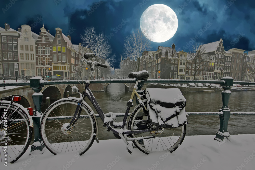 City scenic from snowy Amsterdam in the Netherlands in winter at night
