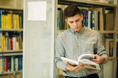 Boy student in library want to find some book. He read the book. Heplful information. study photo