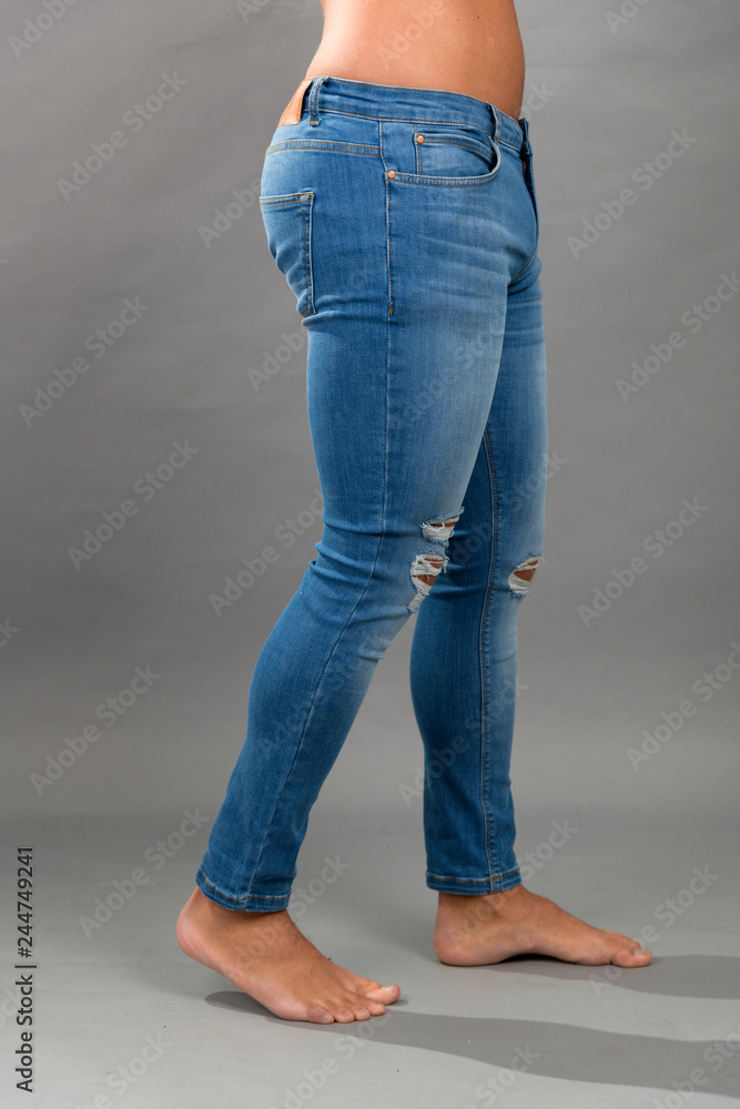 Modern male unbranded Blue skinny ripped jeans isloated on grey background Modern male unbranded Blue skinny ripped jeans isloated on grey background