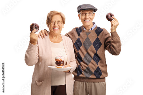 Senior couple holding donuts