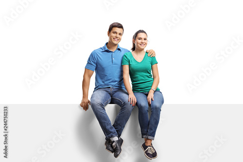 Young casual couple sitting on a panel and smiling at the camera