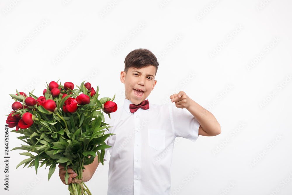 Cheerful boy with bouquet pointing at camera Cheerful boy with bouquet pointing at camera