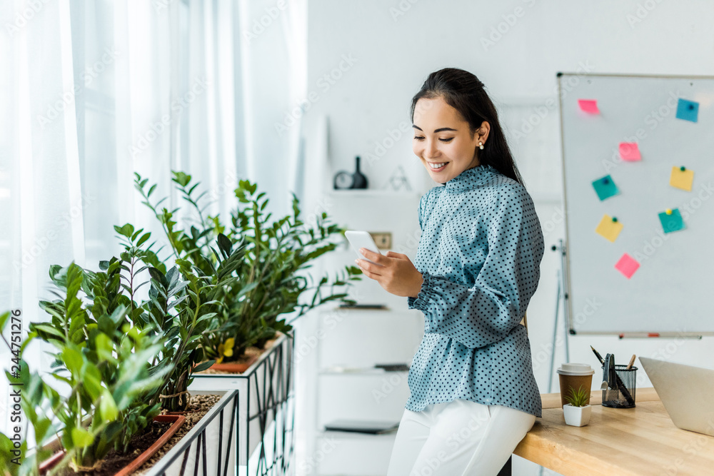 beautiful smiling asian businesswoman using smartphone in office beautiful smiling asian businesswoman using smartphone in office
