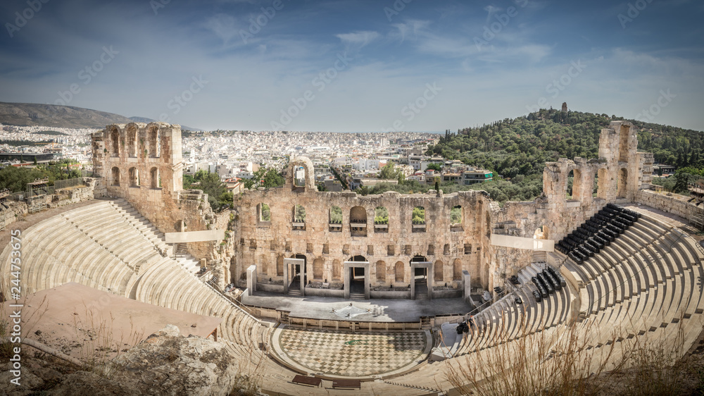 View from above on the theatre of Dionysus, with in the background the white city of Athens under a blue sky