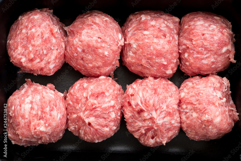 Raw fresh meatballs in black tray, top view Raw fresh meatballs in black tray, top view