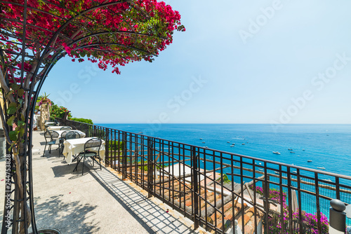 Tables and chairs anad bougainvillea flowers on Positano seafront photo