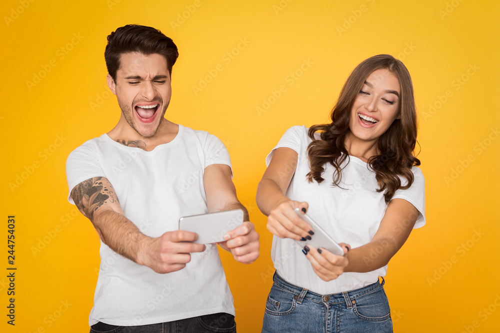 Couple playing video games on mobile phones Couple playing video games on mobile phones