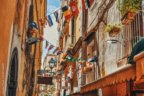 Fototapeta Naklejka Na Ścianę i Meble -  Flags on a narrow alley in old town Sorrento