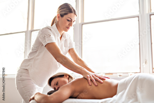 A Woman enjoying spa treatment at salon with masseur worker photo