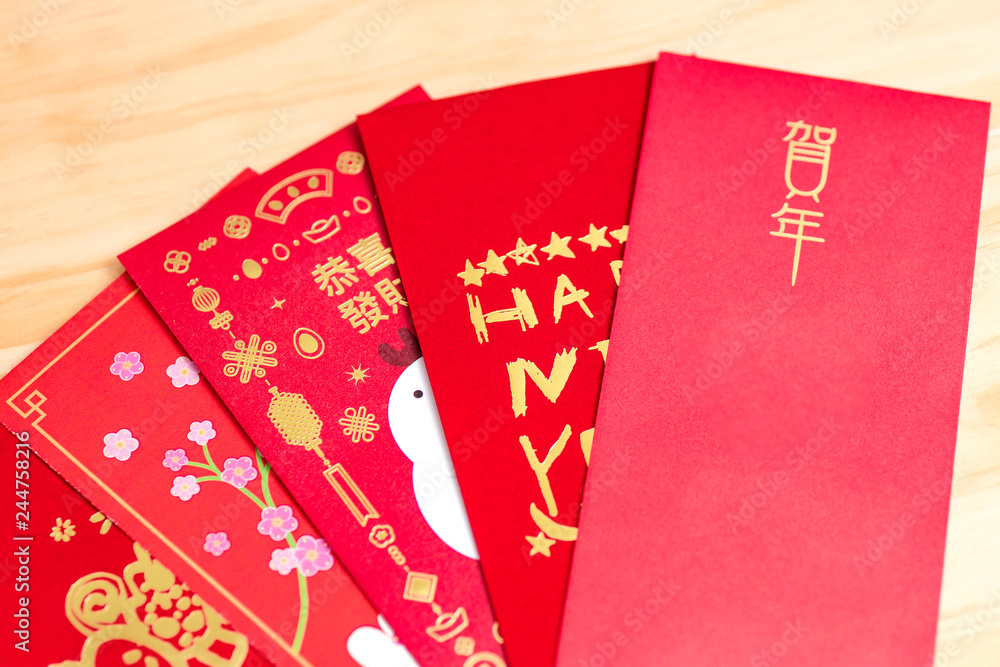 Red envelope packet chinese new year, hongbao with the character 'Happy New Year' on wood background for Chinese New Year. Translation: Good luck in the year Red envelope packet chinese new year, hongbao with the character 'Happy New Year' on wood background for Chinese New Year. Translation: Good luck in the year