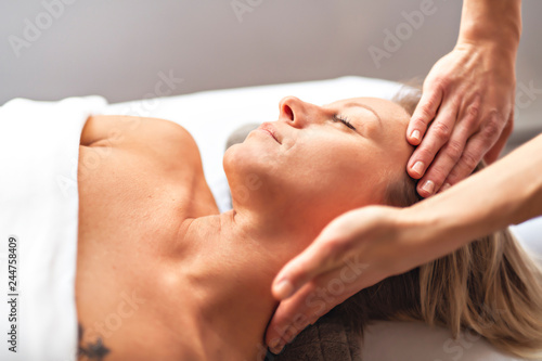 A Woman enjoying spa treatment at salon with masseur worker