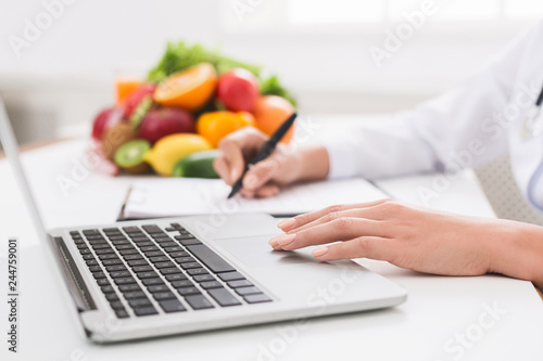 Nutritionist doctor writing diet plan on table photo