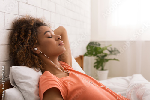 African-american woman relaxing and listening to music photo