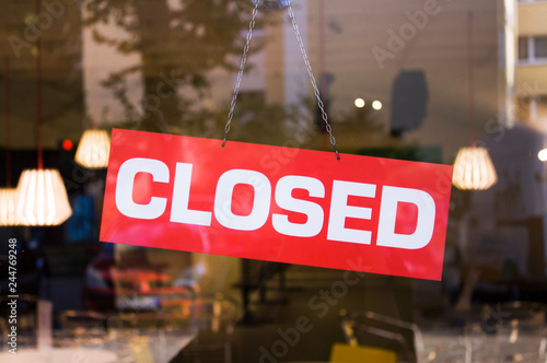 Closed sign on the glass door of the shop