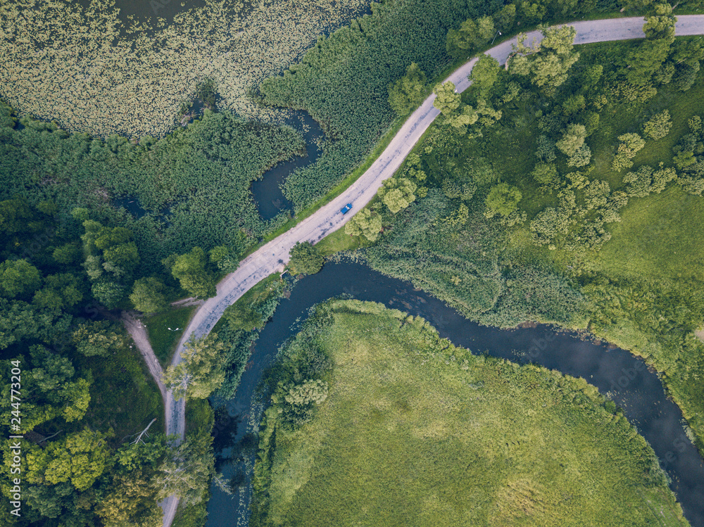 Drone Photo of Car Driving on the Road by the River under the Trees, Top Down View in Early Spring on Sunny Day - Concept of Peaceful Life in Countryside and Traveling, Freedom