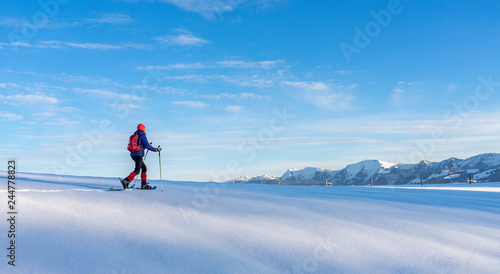 active senior woman snowshoeing in the Allgaeu Alps near Oberstaufen, Bavaria, Germany
