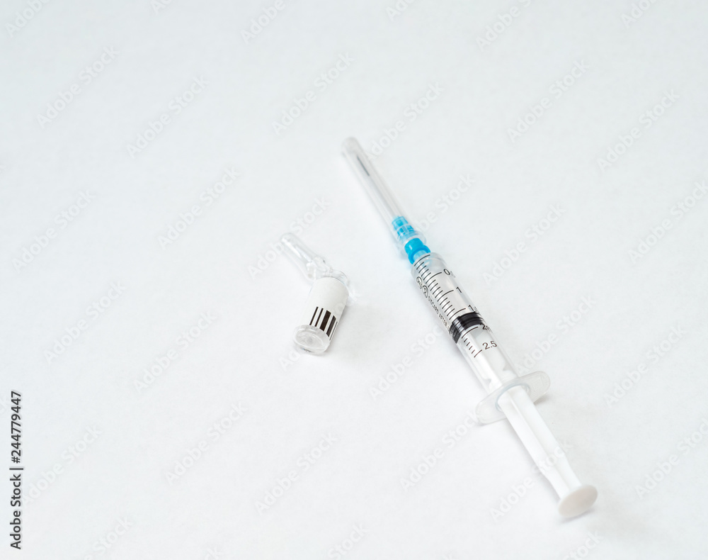 syringe with medicine lies next to the used empty ampoule on a white background syringe with medicine lies next to the used empty ampoule on a white background