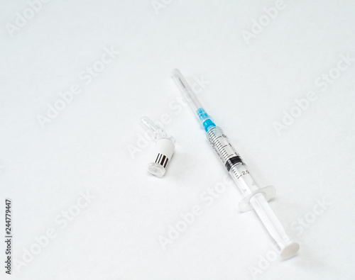 syringe with medicine lies next to the used empty ampoule on a white background