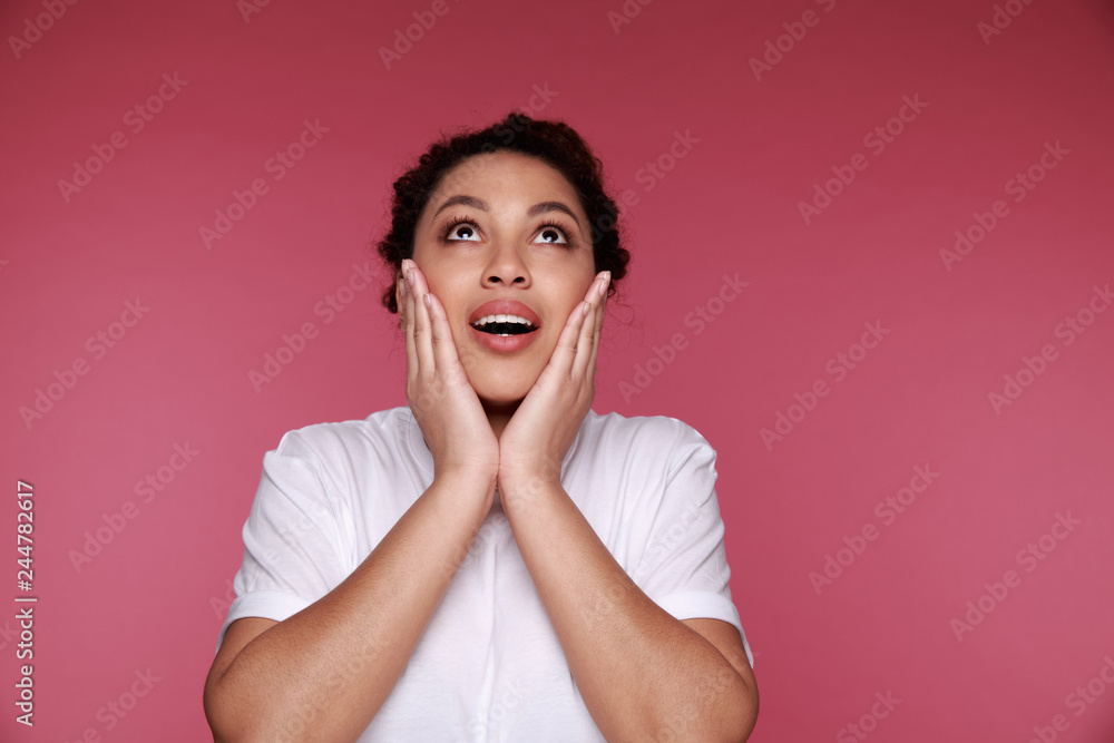 Surprised beautiful black woman holds cheeks by hand Surprised beautiful black woman holds cheeks by hand