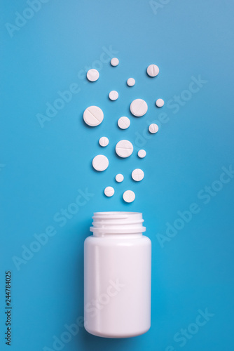 Tablets and bottle on blue background