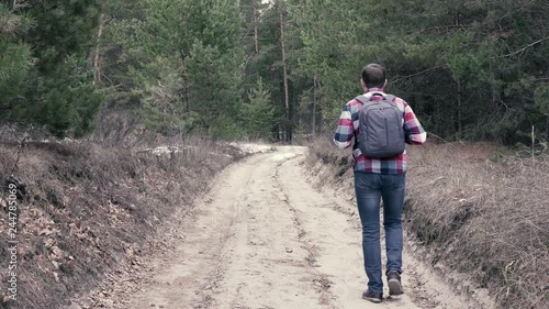 Wallpaper Mural Adult male in casual outfit walking on dirty countryside road and looking around while travelling in nature Torontodigital.ca