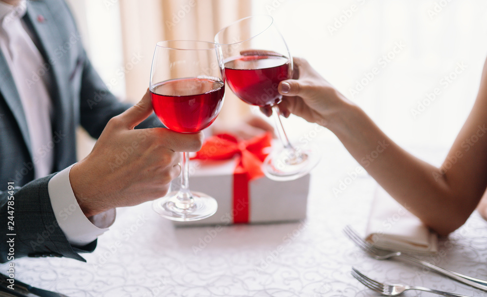 Valentine's Day concept. Happy couple in love with. A young loving couple celebrating Valentine's Day in the restaurant. Lovers give each other gifts. Romance restaurant for Valentine's Day- concept.